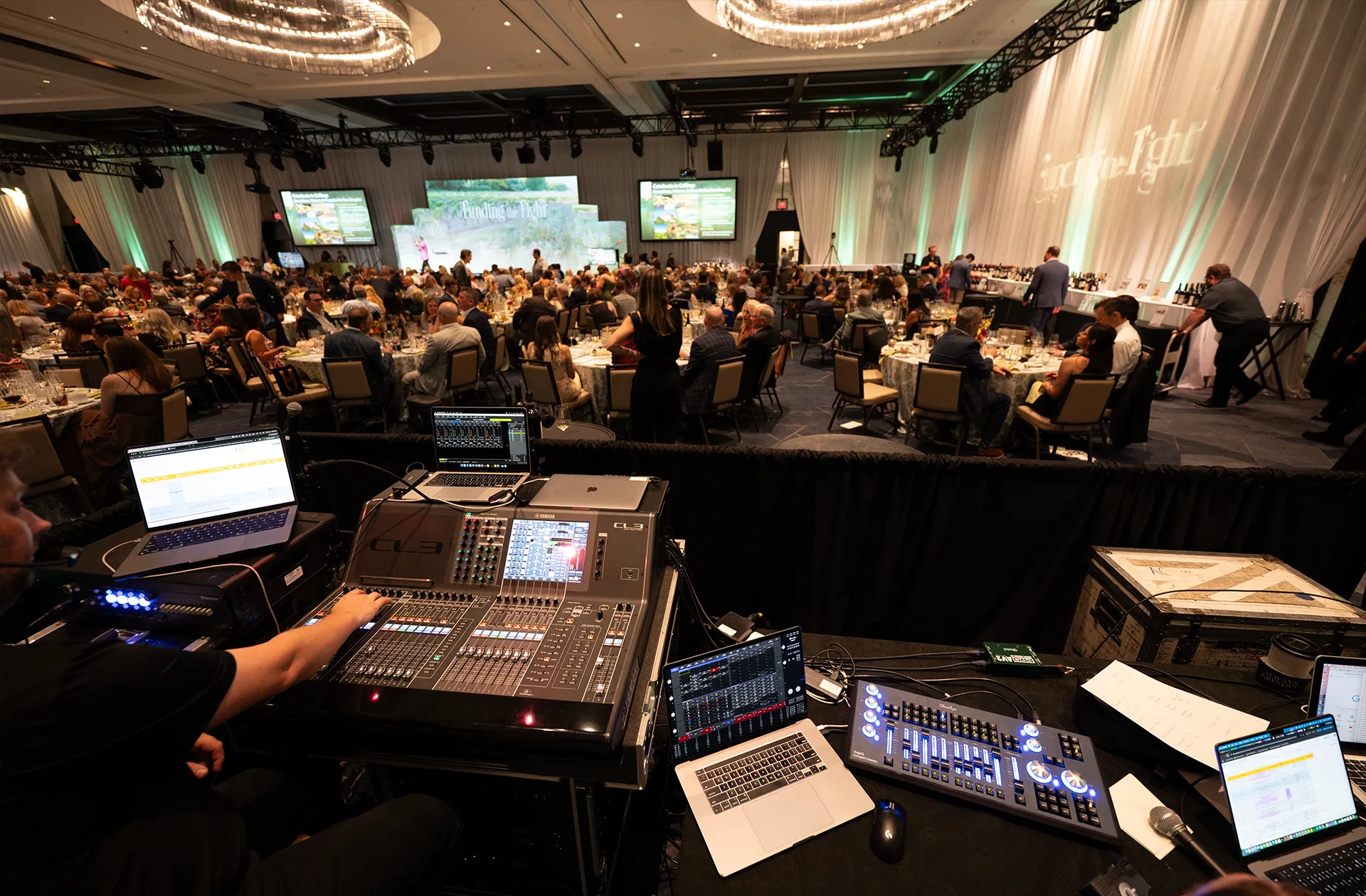 Bluewood Production crew managing AV equipment and video screens during a ballroom gala event.
